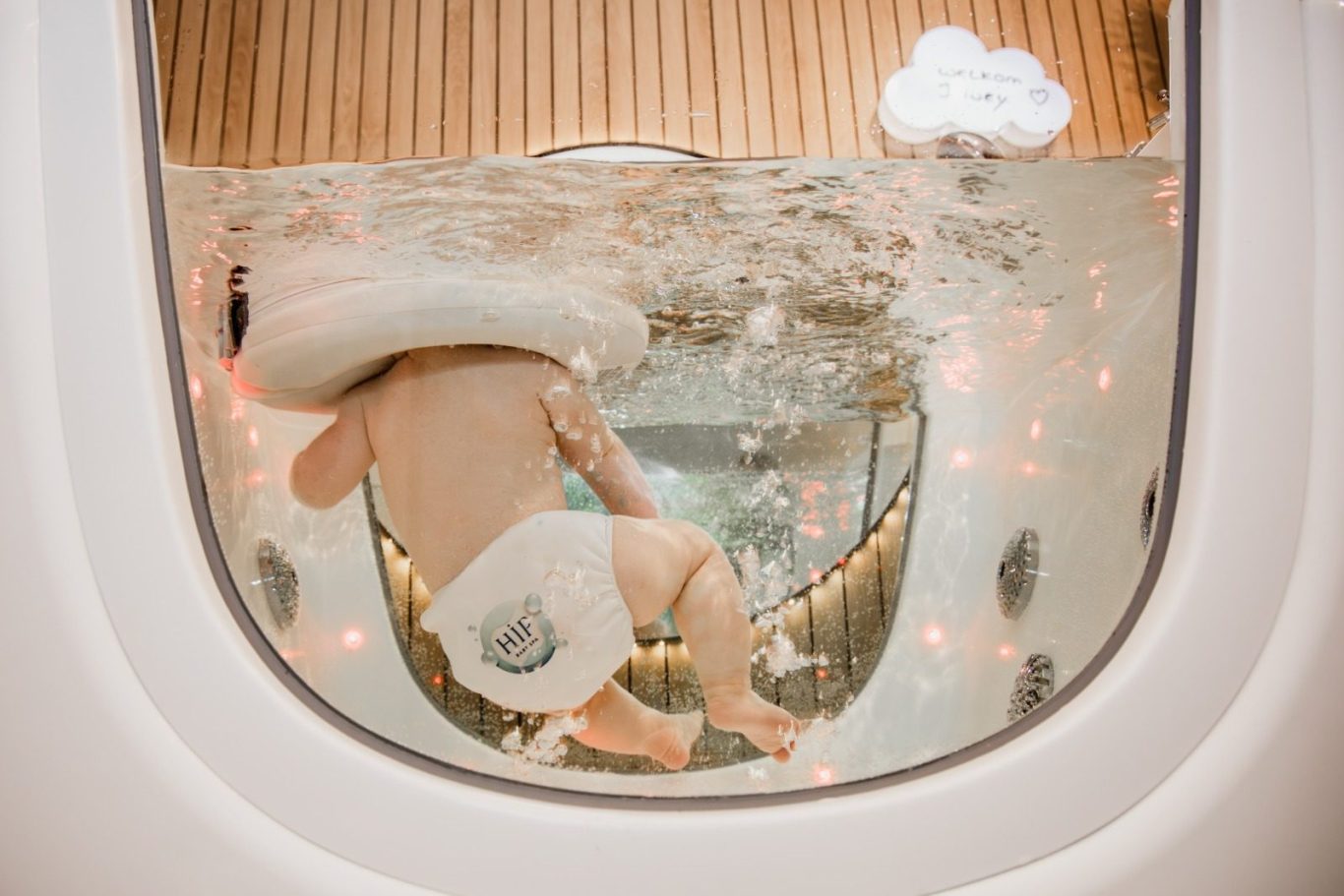 Baby met blauwe ogen heerlijk aan het floaten